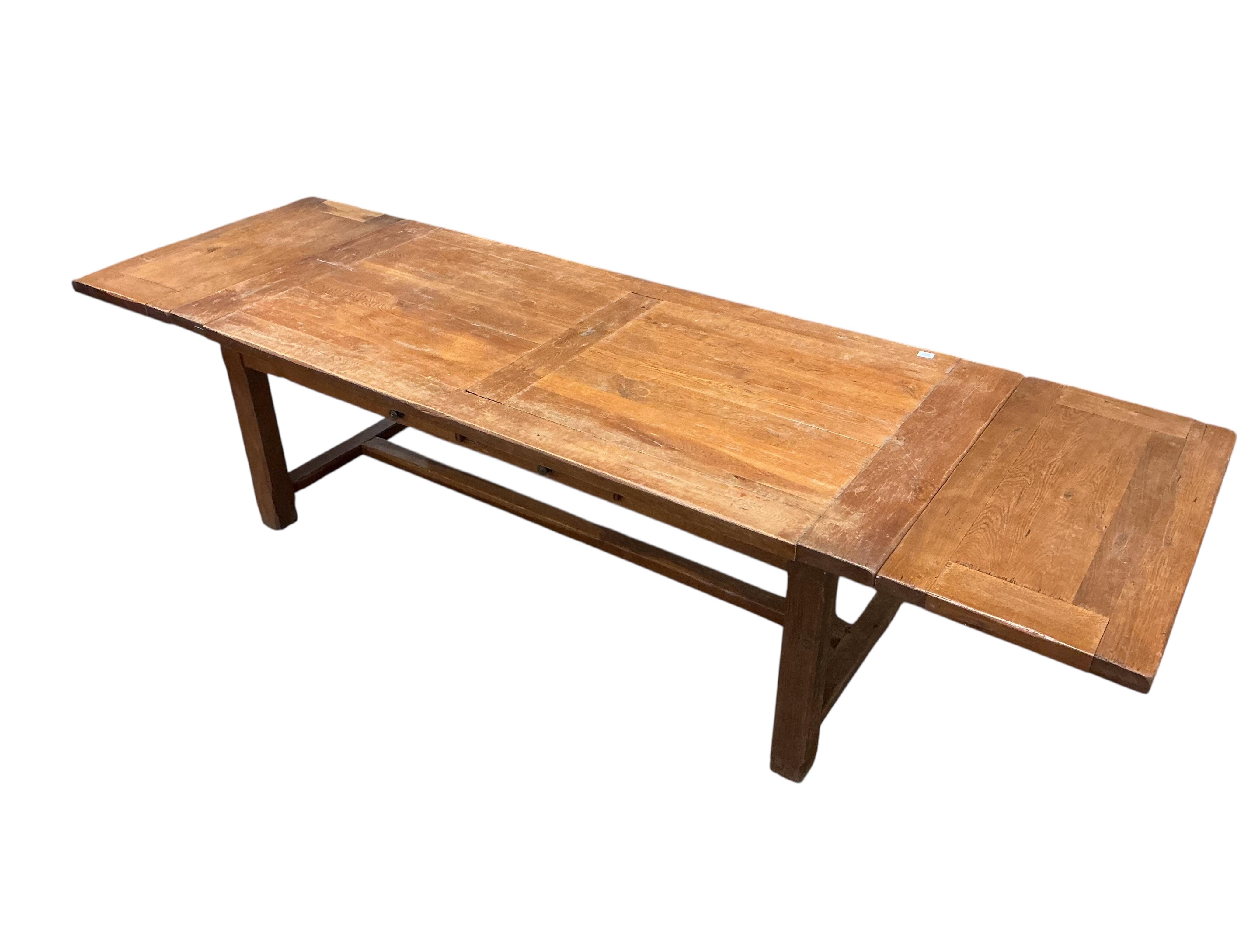 A Contemporary rectangular oak extending refectory dining table, width 320cm extended, two detachable end leaves, depth 100cm, height 76cm together with eight matching ladderback dining chairs, two with arms